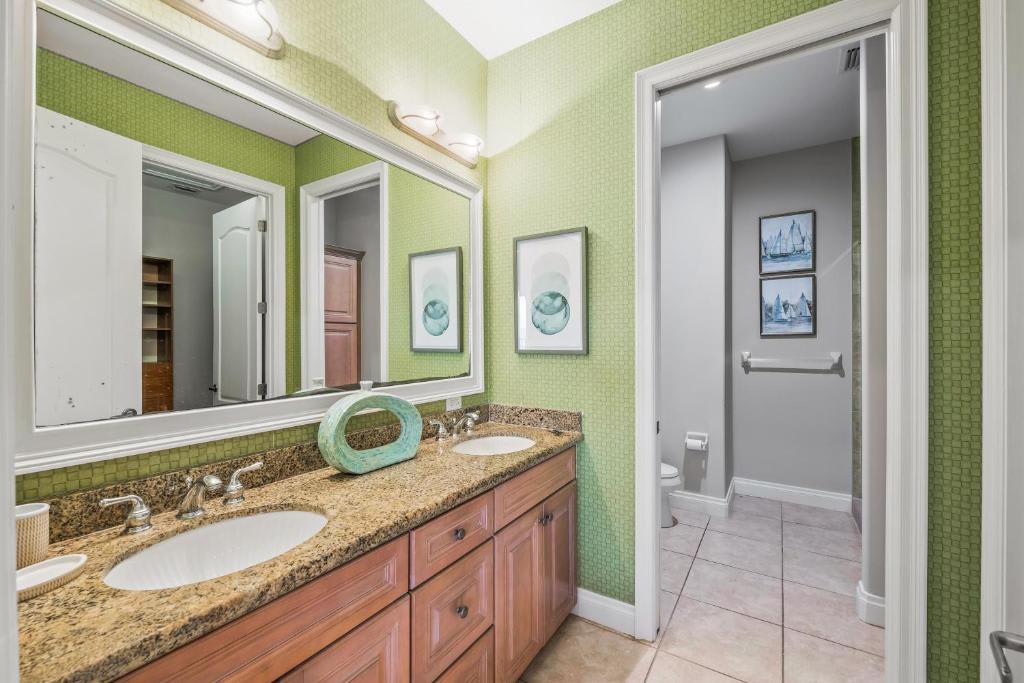 Freshen up in your bright, cheerfully appointed bathroom with a double vanity and granite countertops. The soothing green tile and coastal accents create a serene space where you can start your day refreshed.