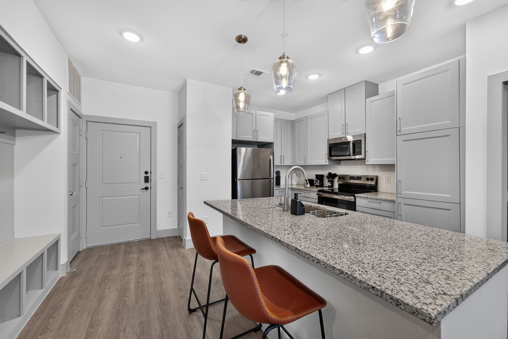 Step into your spacious kitchen where sleek granite countertops meet modern stainless steel appliances. Gather at the breakfast bar beneath elegant pendant lights—perfect for morning coffee or evening conversation.