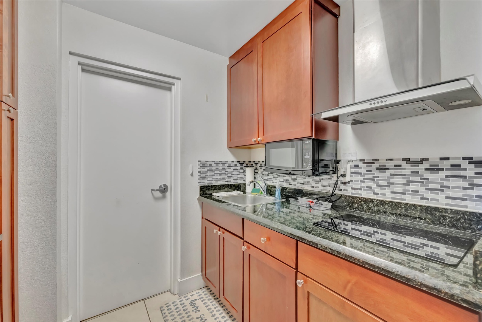 Your well-appointed kitchen features sleek granite countertops, modern tile backsplash, and stainless steel appliances—everything you need to prepare delicious meals during your stay.