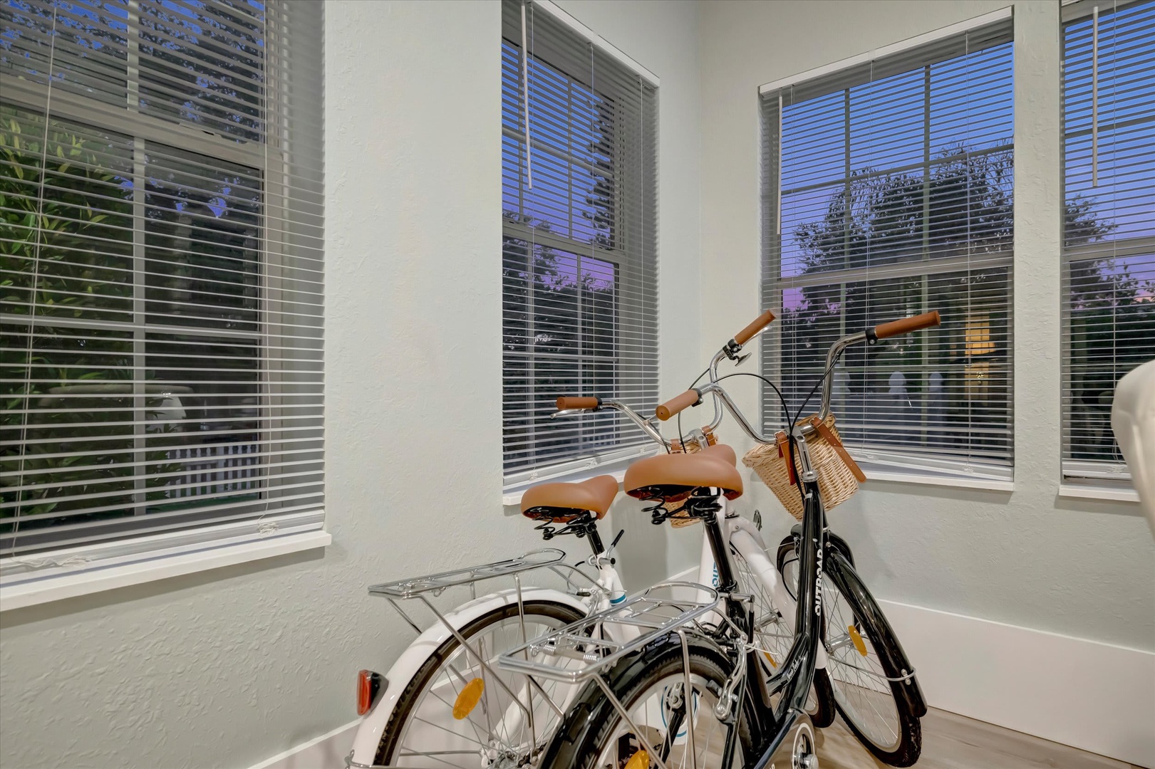 Step into this bright, inviting space where two bicycles await your next adventure. Large windows frame peaceful views of the surrounding neighborhood, filling the room with natural light and a sense of possibility.