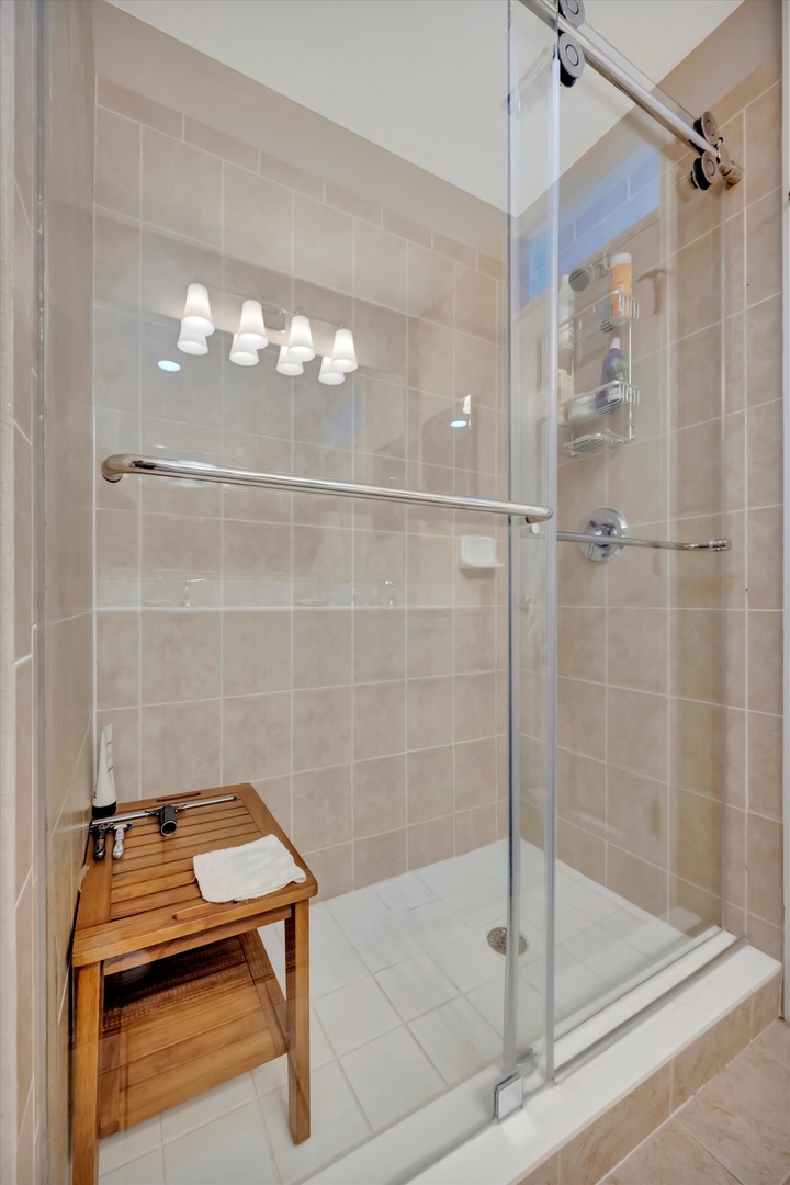 Step into your spa-like bathroom with a spacious walk-in shower featuring sleek glass doors, modern fixtures, and warm neutral tiles that create a serene, relaxing atmosphere.
