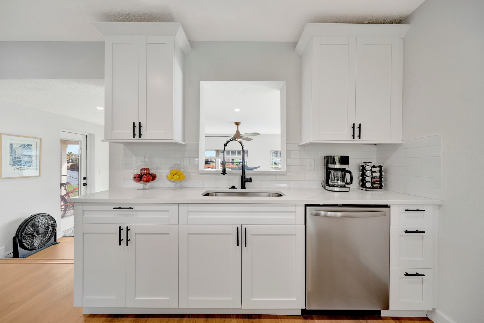 Your gleaming kitchen awaits with crisp white cabinetry, stainless appliances, and a welcoming sink overlooking the bright outdoors—ready for your morning coffee ritual or an evening of home-cooked meals.