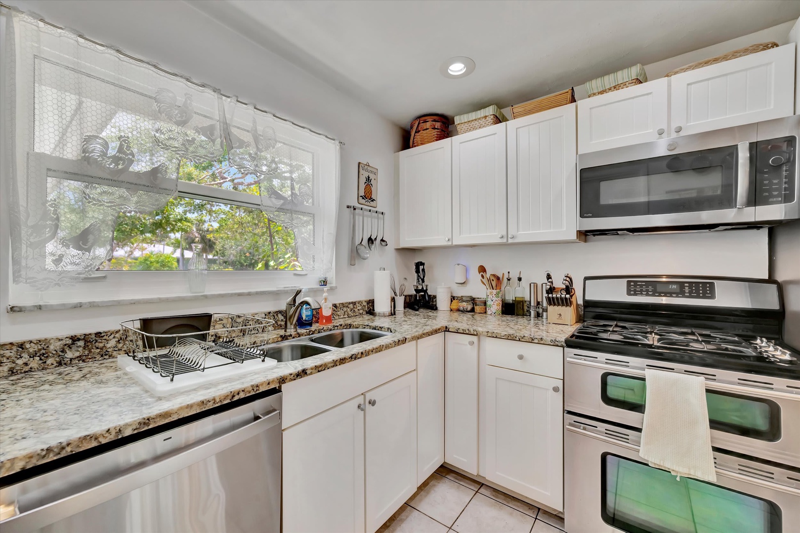 Your fully equipped kitchen features granite countertops, stainless appliances, and a bright garden window that fills the space with natural light—perfect for preparing homemade meals.