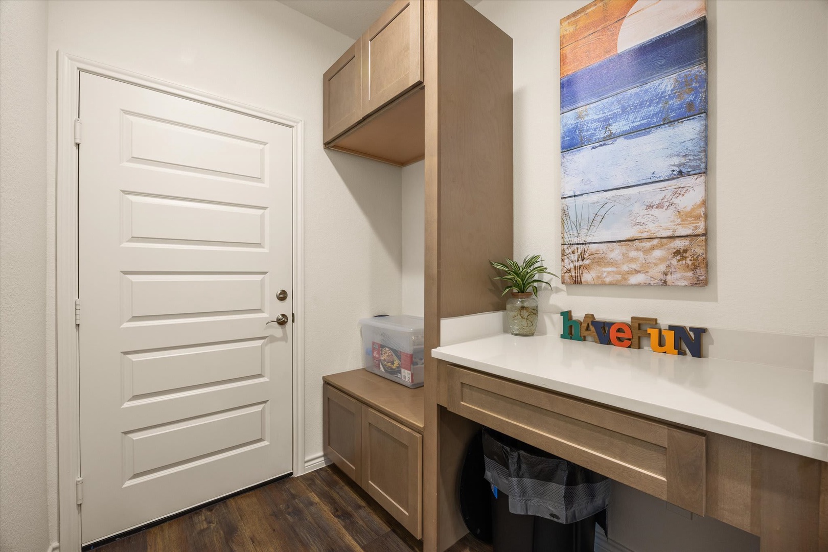 Thoughtfully designed entryway with warm wood tones and clean surfaces. Built-in workspace and clever storage keep you organized for your coastal getaway.