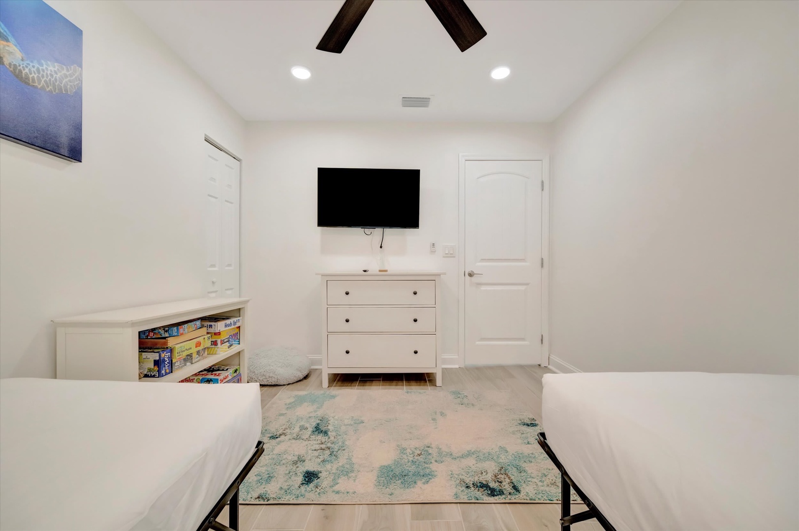 Rest easy in this bright, comfortable bedroom with two inviting beds, ceiling fan, and entertainment ready when you are. Kids will love the bookshelf stocked with games and fun.