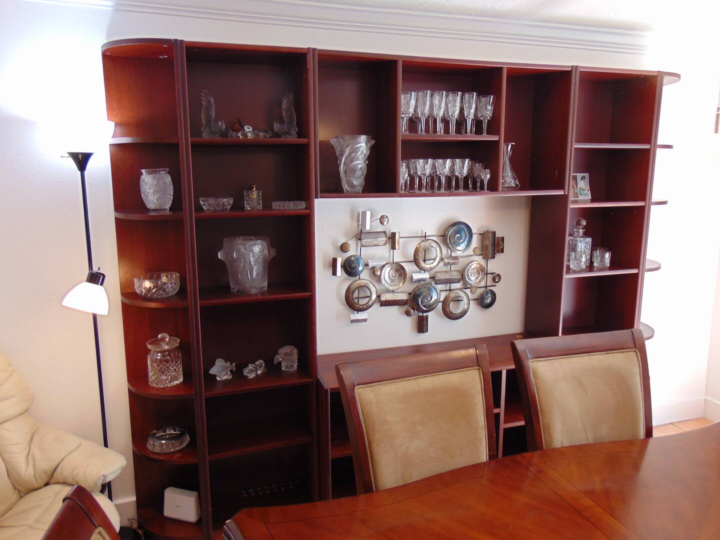 Step into your elegant dining space, where rich wood shelving displays crystal glassware and decorative pieces, setting the perfect stage for memorable meals together.