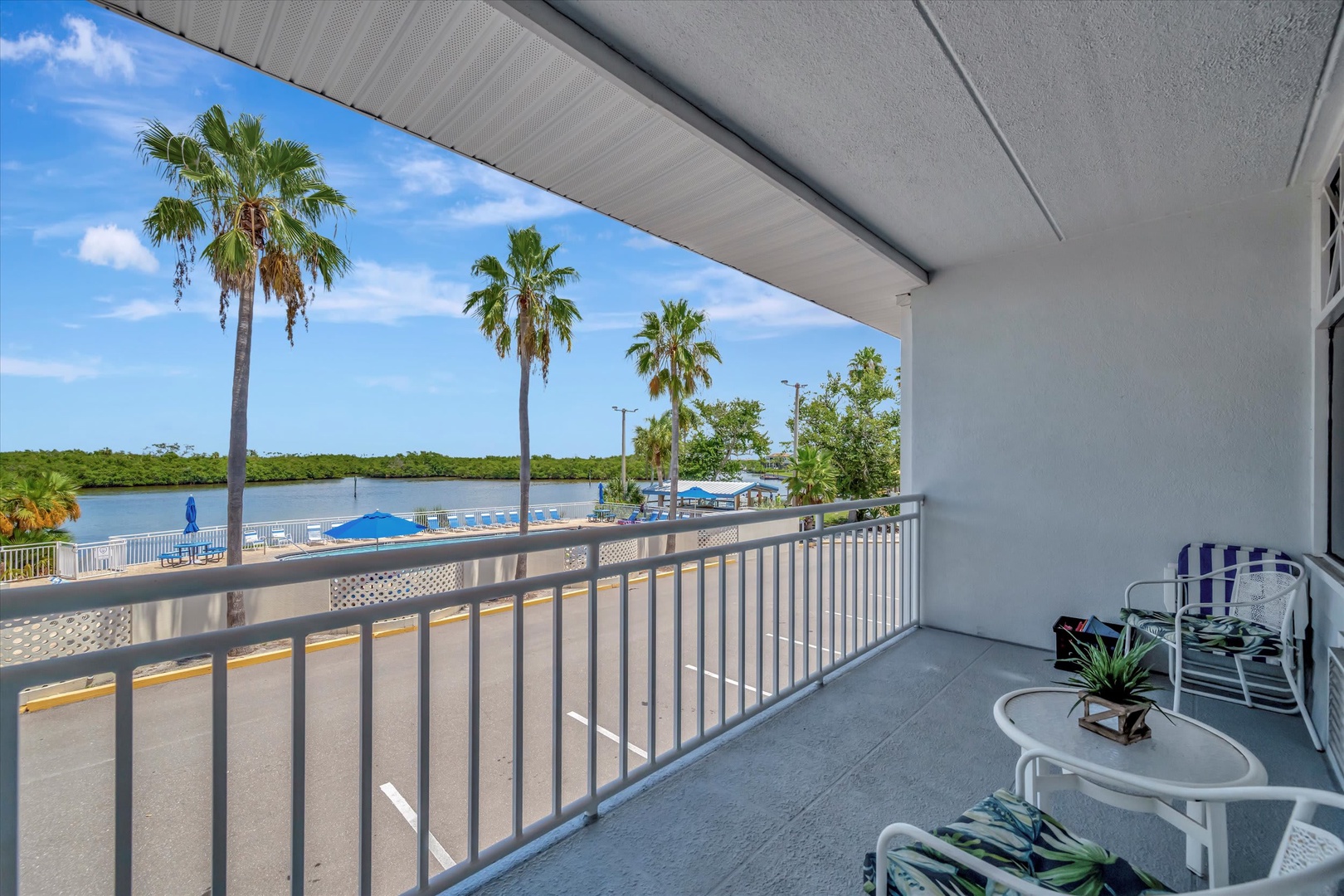 A spacious balcony overlooks swaying palms and serene waterfront views, offering you a peaceful spot to relax with your morning coffee or unwind as the day fades.