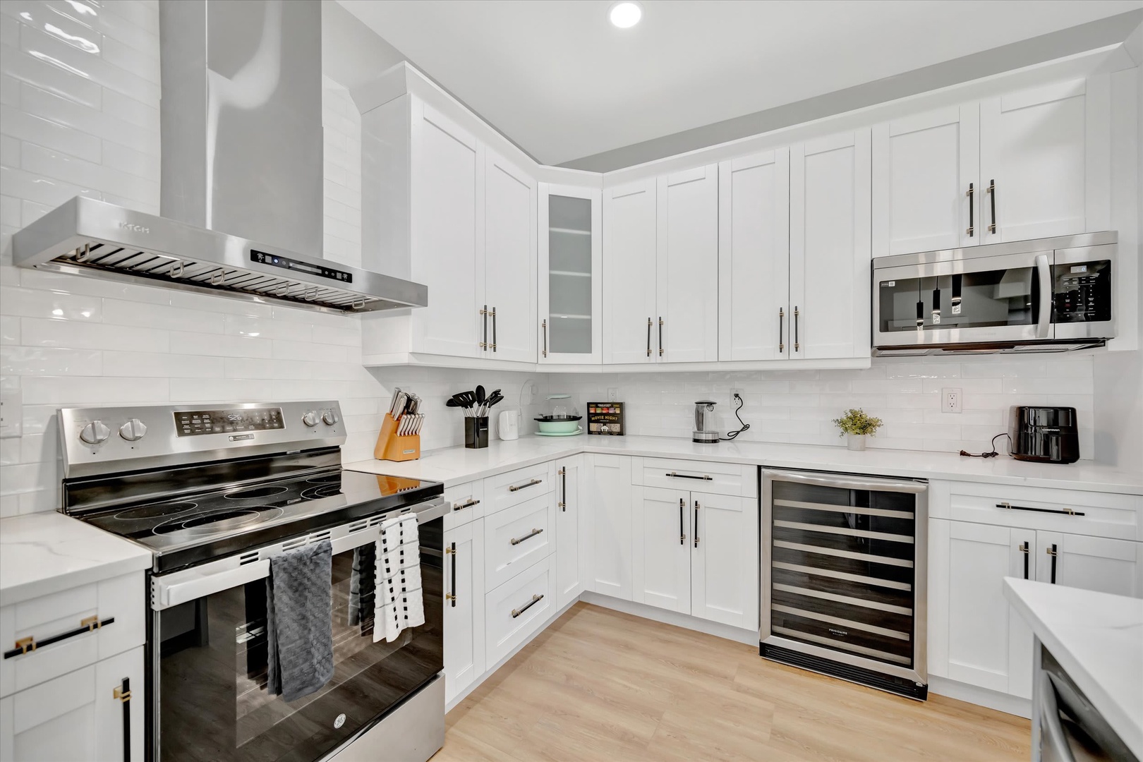 Your chef-ready kitchen features sleek white cabinetry, stainless appliances, and pristine countertops—perfect for whipping up vacation meals or savoring morning coffee in bright, modern comfort.