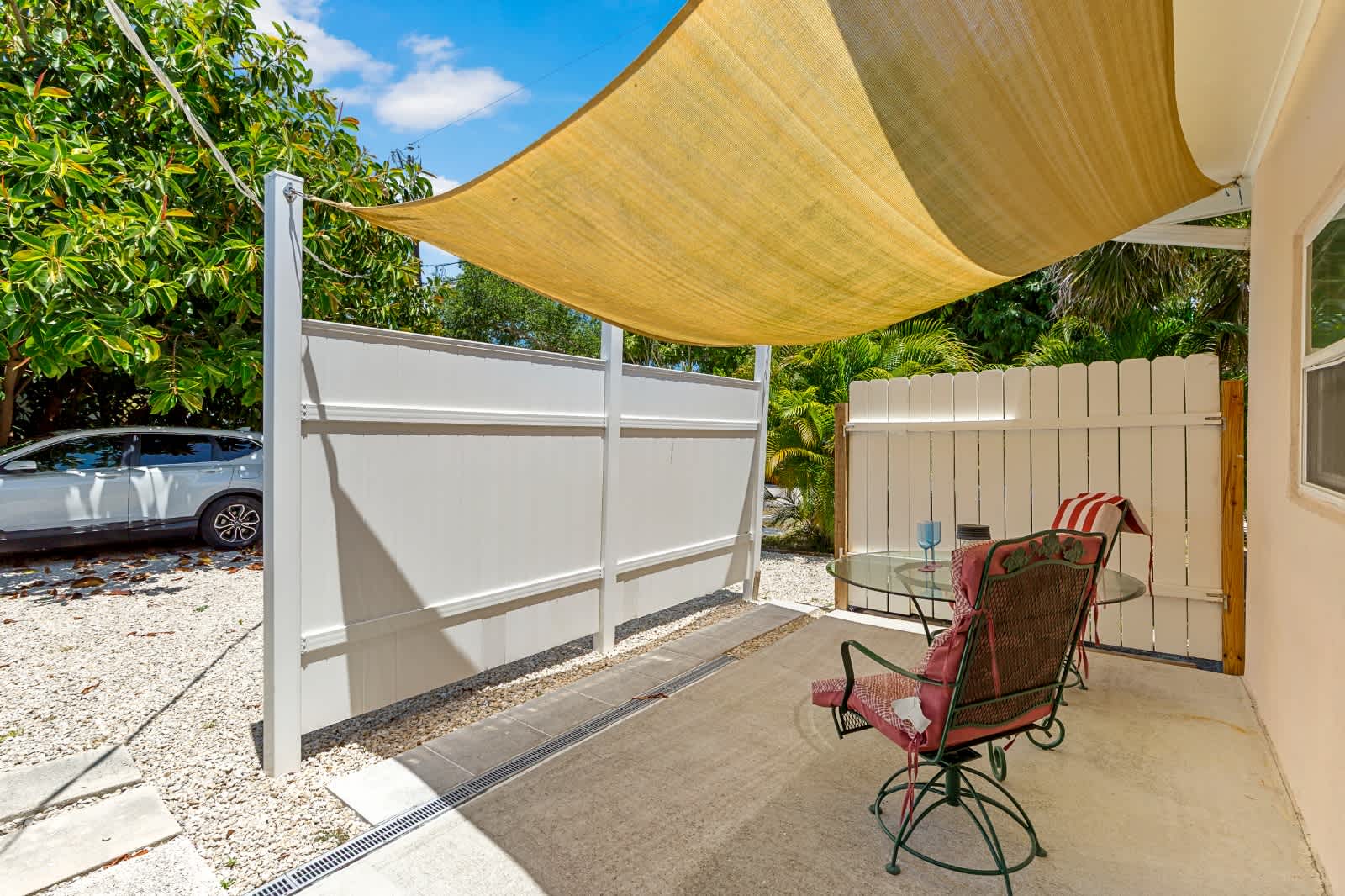 This serene private patio offers a shaded retreat where you can unwind with your morning coffee or evening drink surrounded by lush tropical greenery.