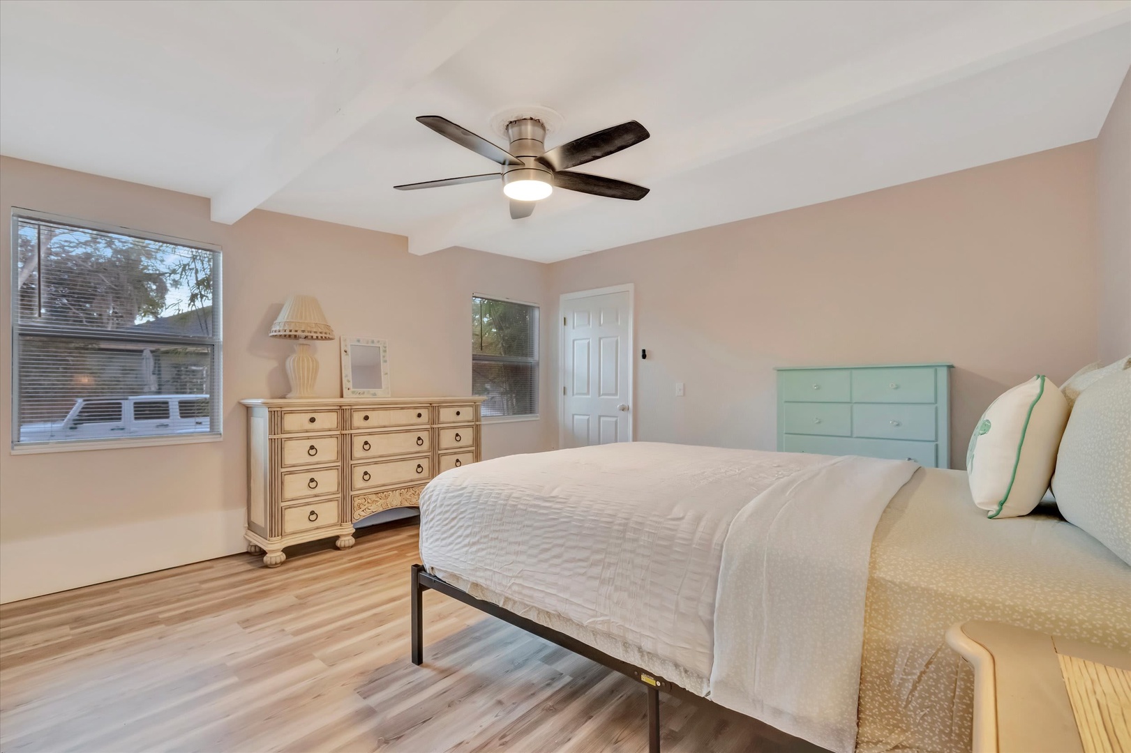 Drift off in this peaceful bedroom with soft coastal colors, fresh linens, and a ceiling fan to keep you cool. Natural light fills the room, making mornings feel effortless and restful.