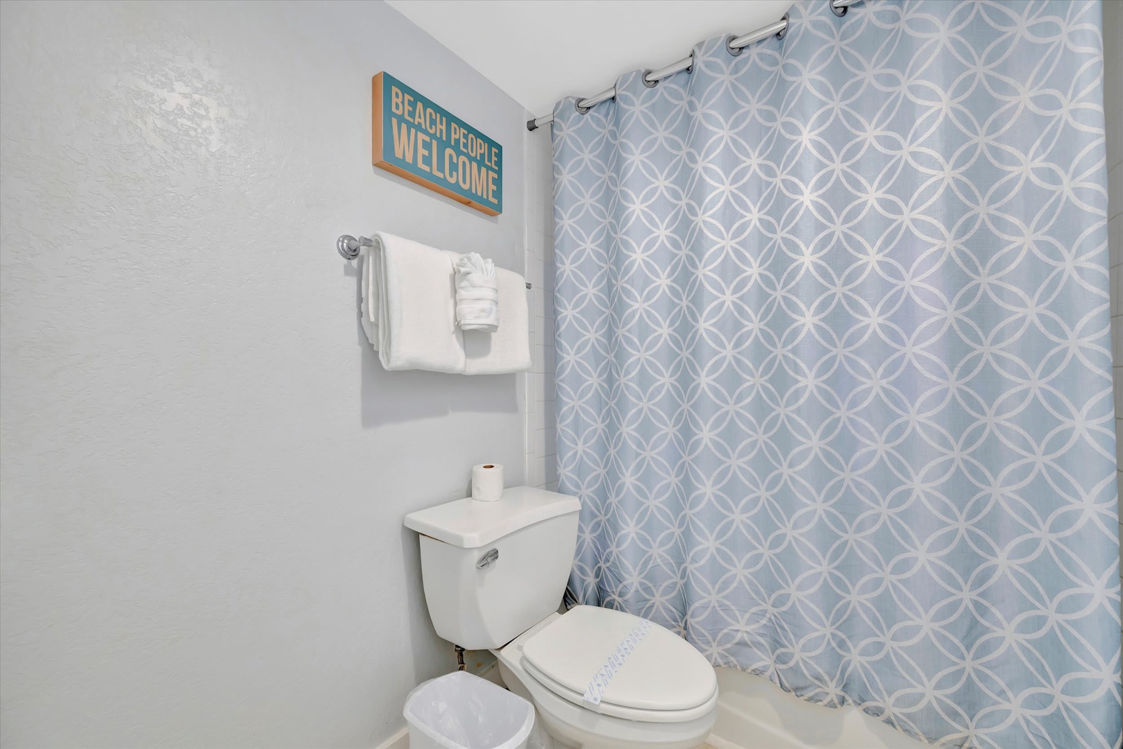 Your coastal-themed bathroom features fresh white towels, playful beach decor, and a cheerful curtain that sets a breezy, relaxed tone for your stay.