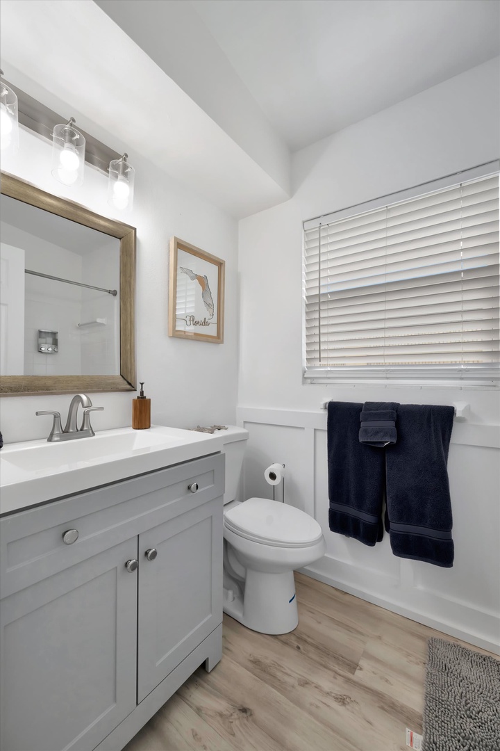 Freshen up in your private bathroom with a spacious tub-shower combo, modern vanity, and coastal touches. Crisp white finishes and soft natural light create a relaxing retreat.