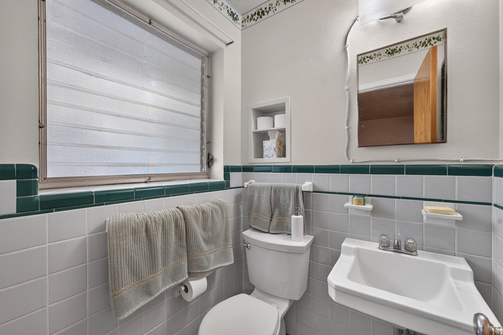 Freshen up in your charming vintage bathroom, where crisp white subway tiles meet vibrant teal accents. Plush towels and thoughtful touches make this space feel both classic and welcoming.