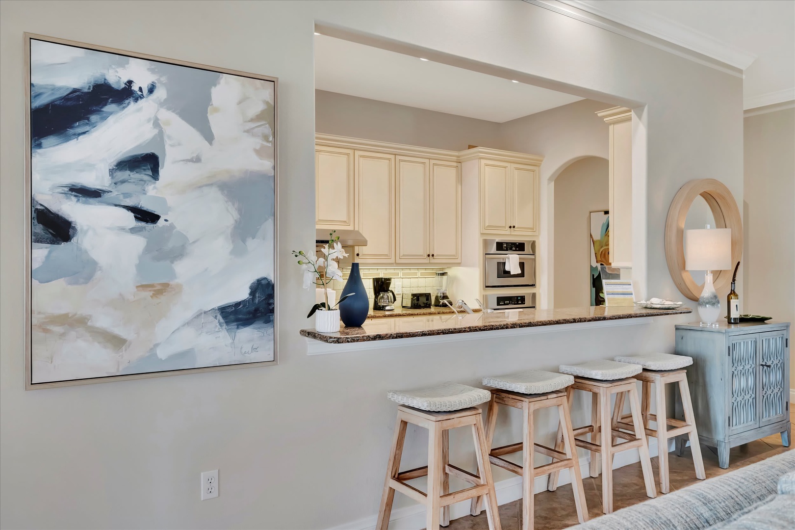 Step into this bright, open kitchen where breakfast bar seating invites you to linger over morning coffee. Elegant cream cabinetry and warm granite countertops create a welcoming space for cooking and gathering.