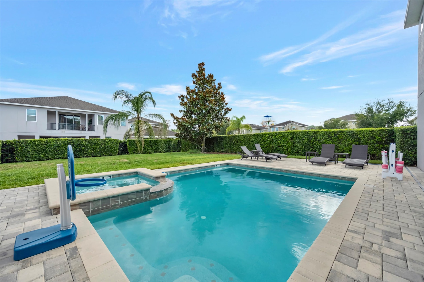 Dive into your private paradise with a sparkling pool and hot tub, surrounded by lush landscaping and plenty of loungers for soaking up the Florida sunshine.