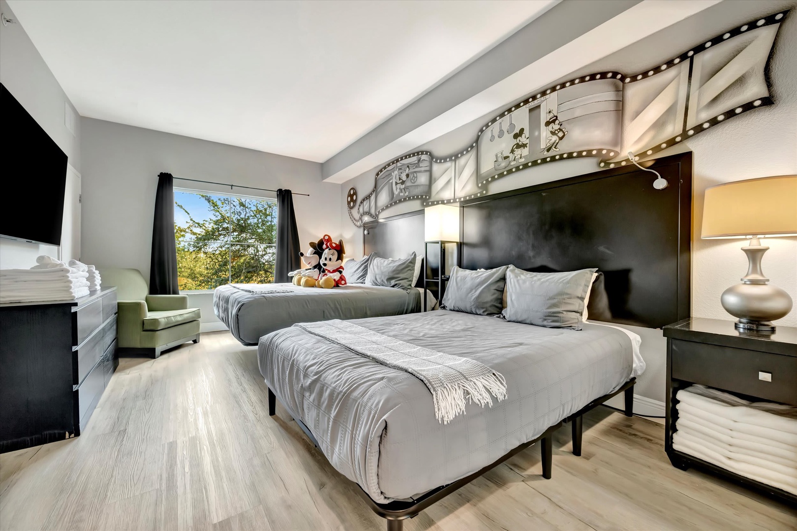 Settle into your elegantly appointed bedroom featuring two plush queen beds, a creative cinema-inspired headboard, and garden views through the window—a perfect retreat after your day's adventures.