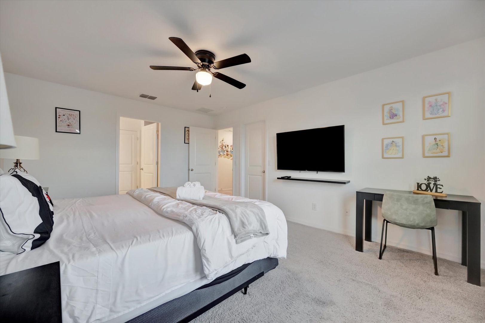 Unwind in your spacious bedroom with plush bedding, a ceiling fan for comfort, and a workspace for your convenience. The en-suite access ensures privacy while you relax.