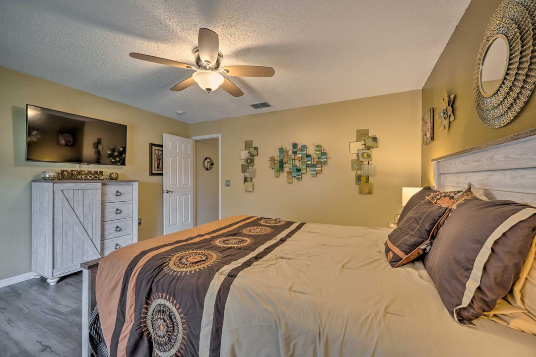 Your spacious bedroom features a plush bed with stylish linens, a ceiling fan, and thoughtful decor that creates a warm, restful retreat after your day's adventures.