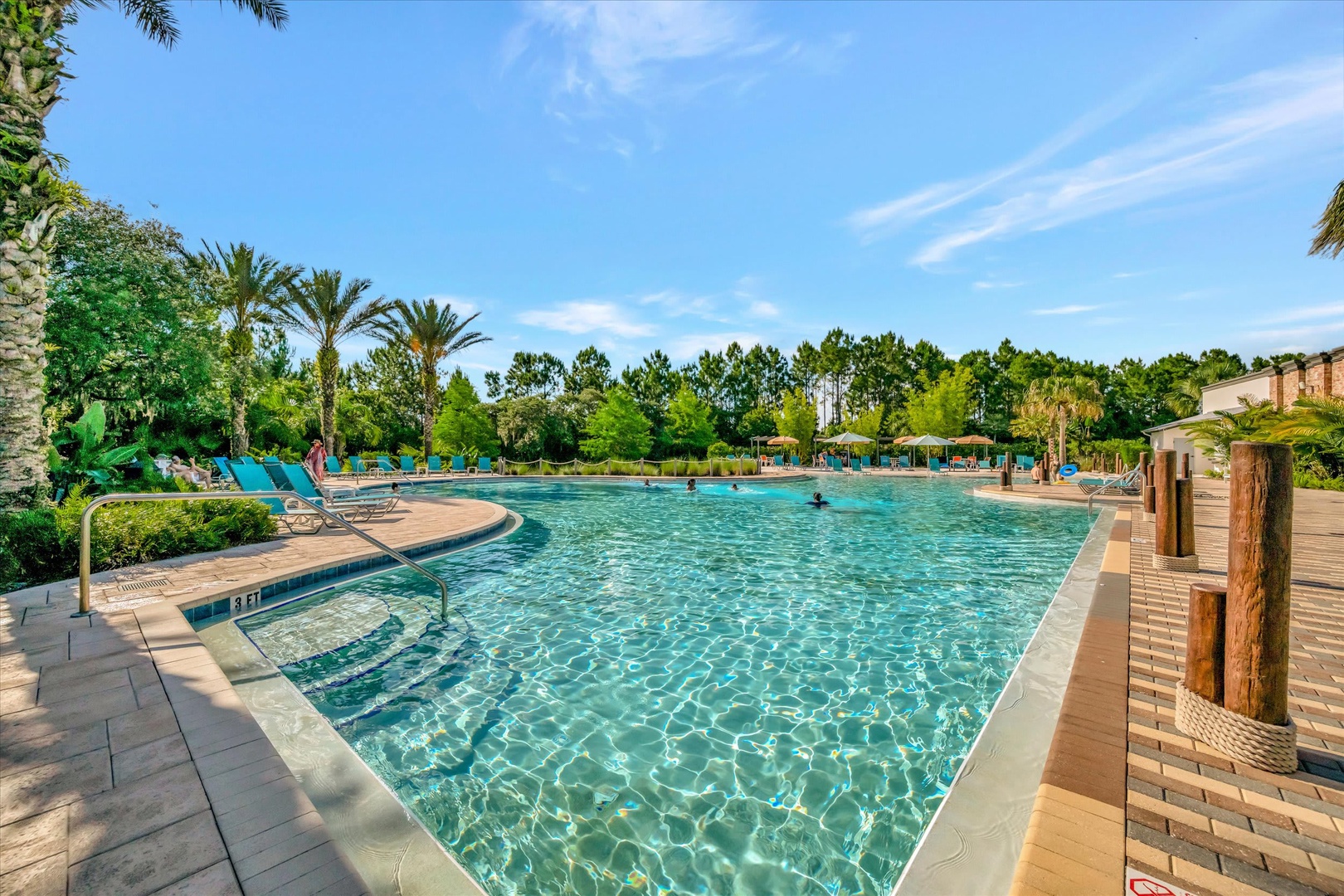 A sparkling resort-style pool surrounded by lush palm trees and tropical landscaping invites you to relax under clear blue skies and soak up the sunshine.