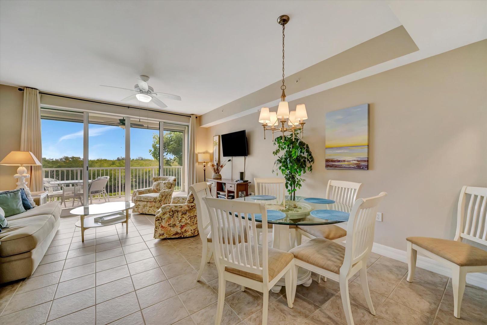 This bright, open space flows seamlessly from cozy seating to your dining table, all bathed in natural light from the balcony beyond. Gather here to share meals and stories in your comfortable home away from home.