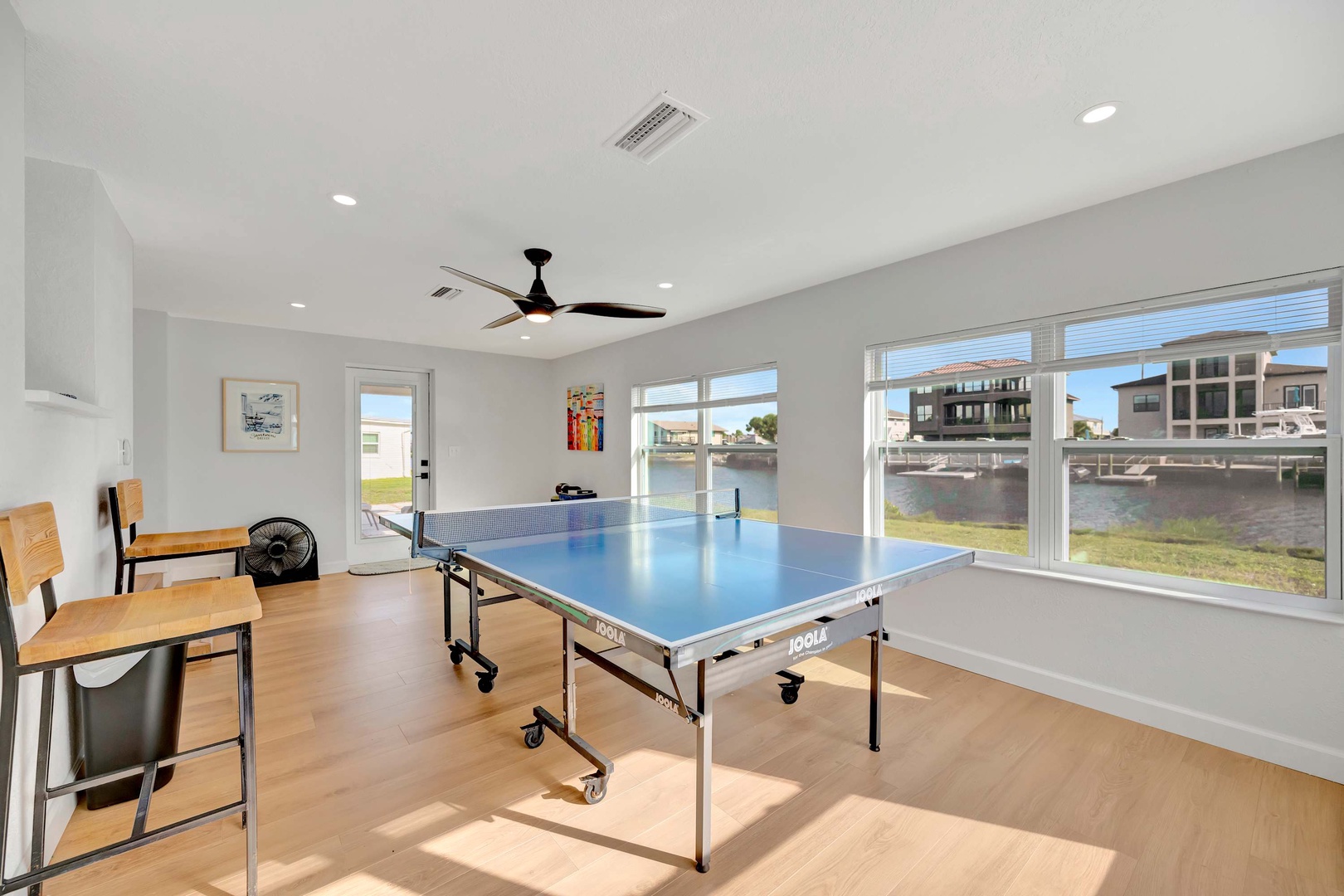 Step into your own game room where a table tennis setup awaits by the water. Challenge friends, enjoy the natural light streaming through the windows, and relax with peaceful canal views just beyond.