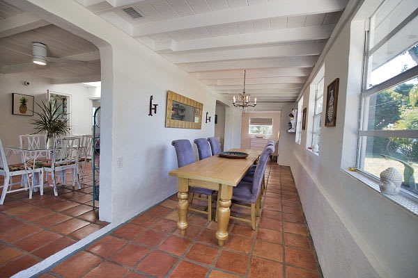 Gather around the rustic wooden table where you'll share meals in this sun-filled dining space, with terracotta tiles underfoot and natural light pouring through the windows.