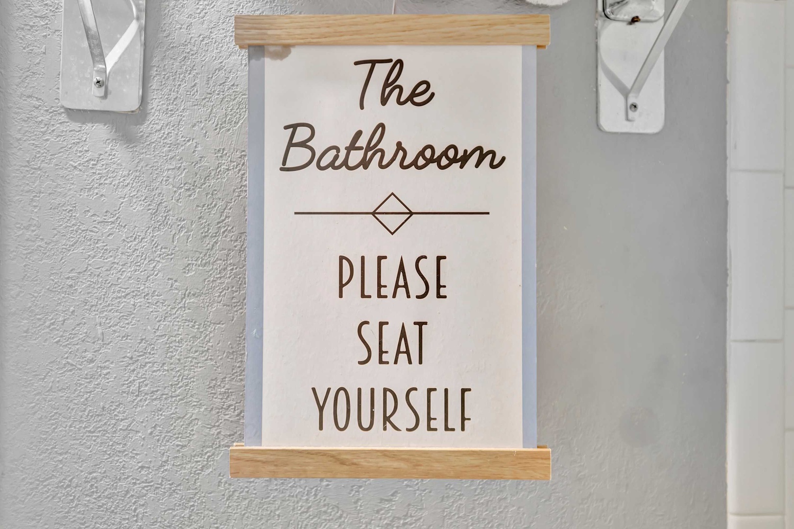 A lighthearted sign adds personality to your bathroom, welcoming you with a touch of humor and charm.
