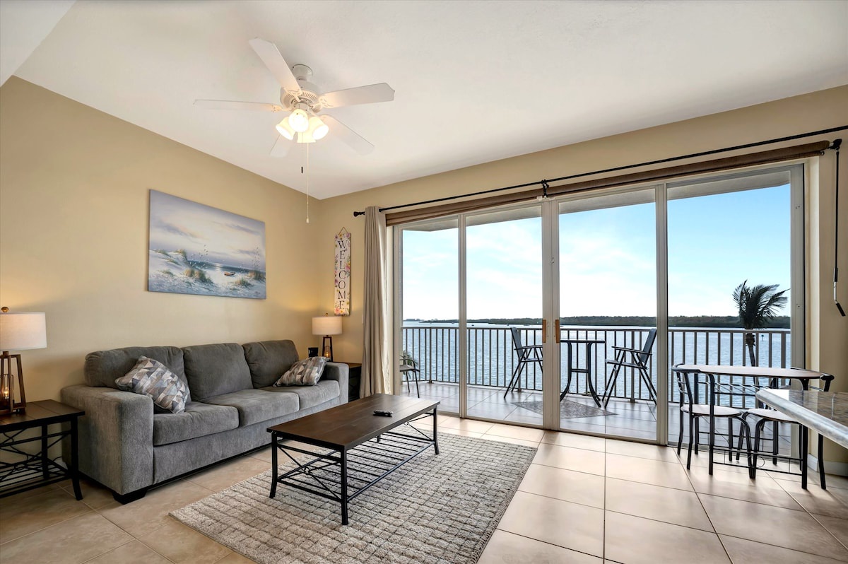 Relax in your bright, comfortable living room with a stunning view of the water stretching across the horizon—your perfect spot to unwind and soak in the scenery.