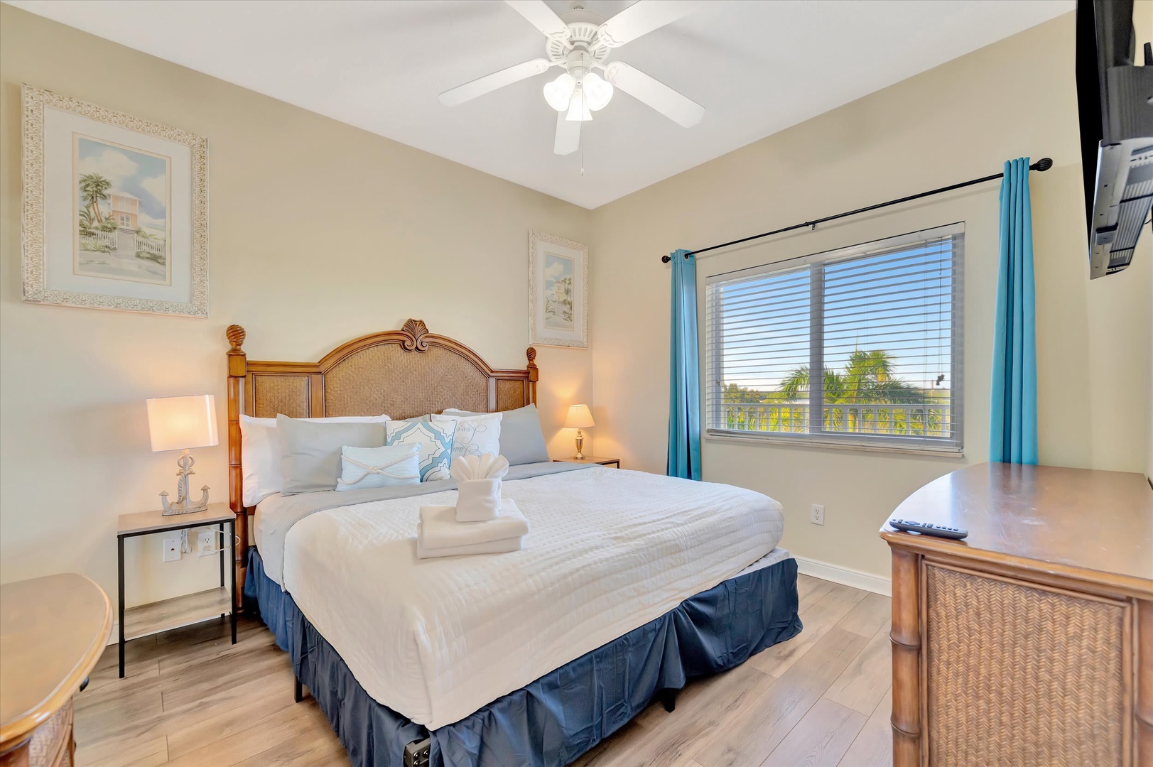 Your bedroom offers a peaceful retreat with soft linens, coastal artwork, and a gentle breeze from the ceiling fan—everything you need to unwind after a day of exploring.