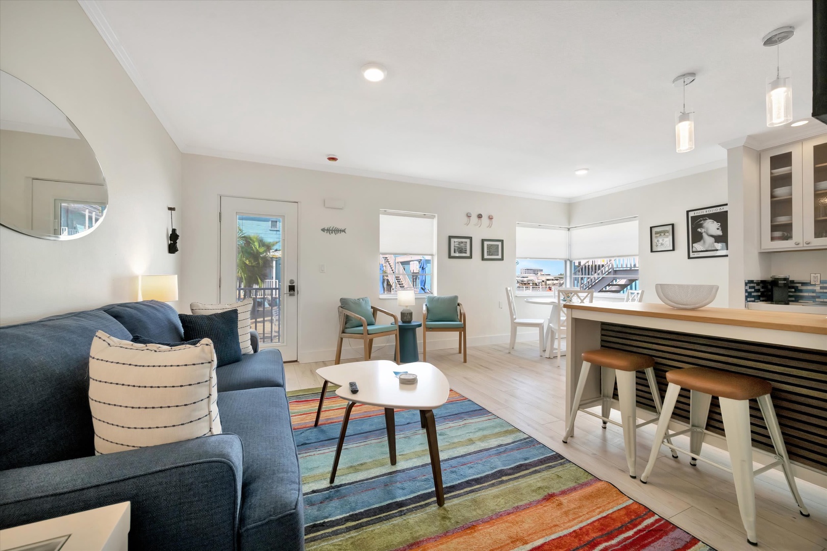 Sink into the plush sofa and unwind in this bright, coastal-inspired living space, where natural light spills through open views and every detail invites you to relax.