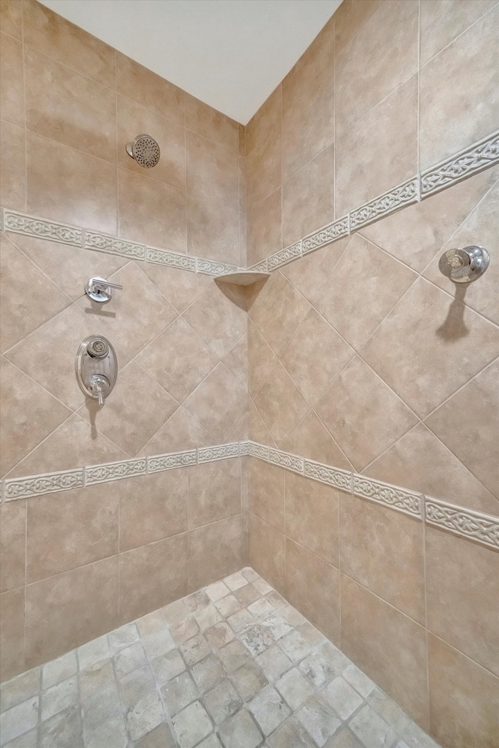 Step into your beautifully tiled walk-in shower with dual fixtures and elegant decorative accents. The spacious enclosure and thoughtful design invite you to unwind after a day of adventure.