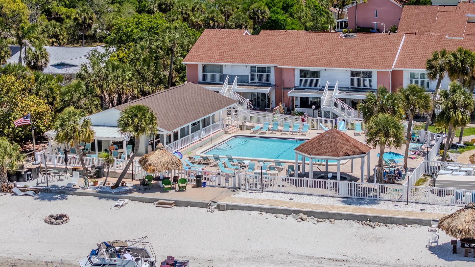 Beachfront property featuring multi-level accommodations, poolside lounge areas, and direct sandy beach access for your coastal getaway.