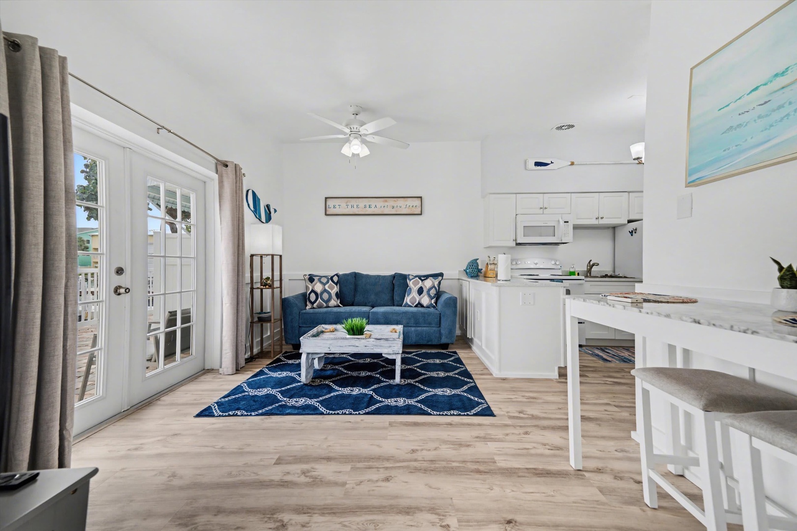 Relax in your bright, coastal-inspired living space with cozy seating and a fully equipped kitchen at your fingertips. The airy layout flows effortlessly, making it easy to unwind or prepare a meal after a day of exploring.