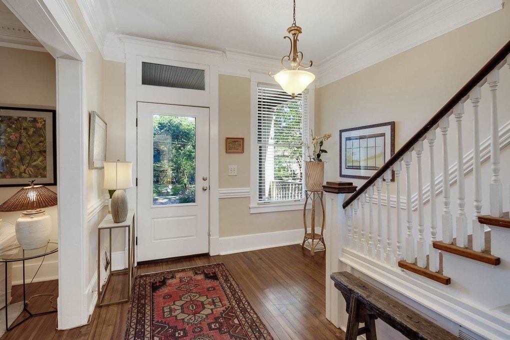 The welcoming entryway greets you with warm hardwood floors, classic architectural details, and natural light streaming through the glass door—your inviting arrival to a beautifully appointed home.