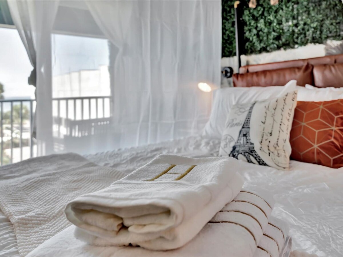 Sink into crisp linens and plush pillows in your bright, welcoming bedroom. Step through sheer curtains to your private balcony and bask in natural light streaming through.