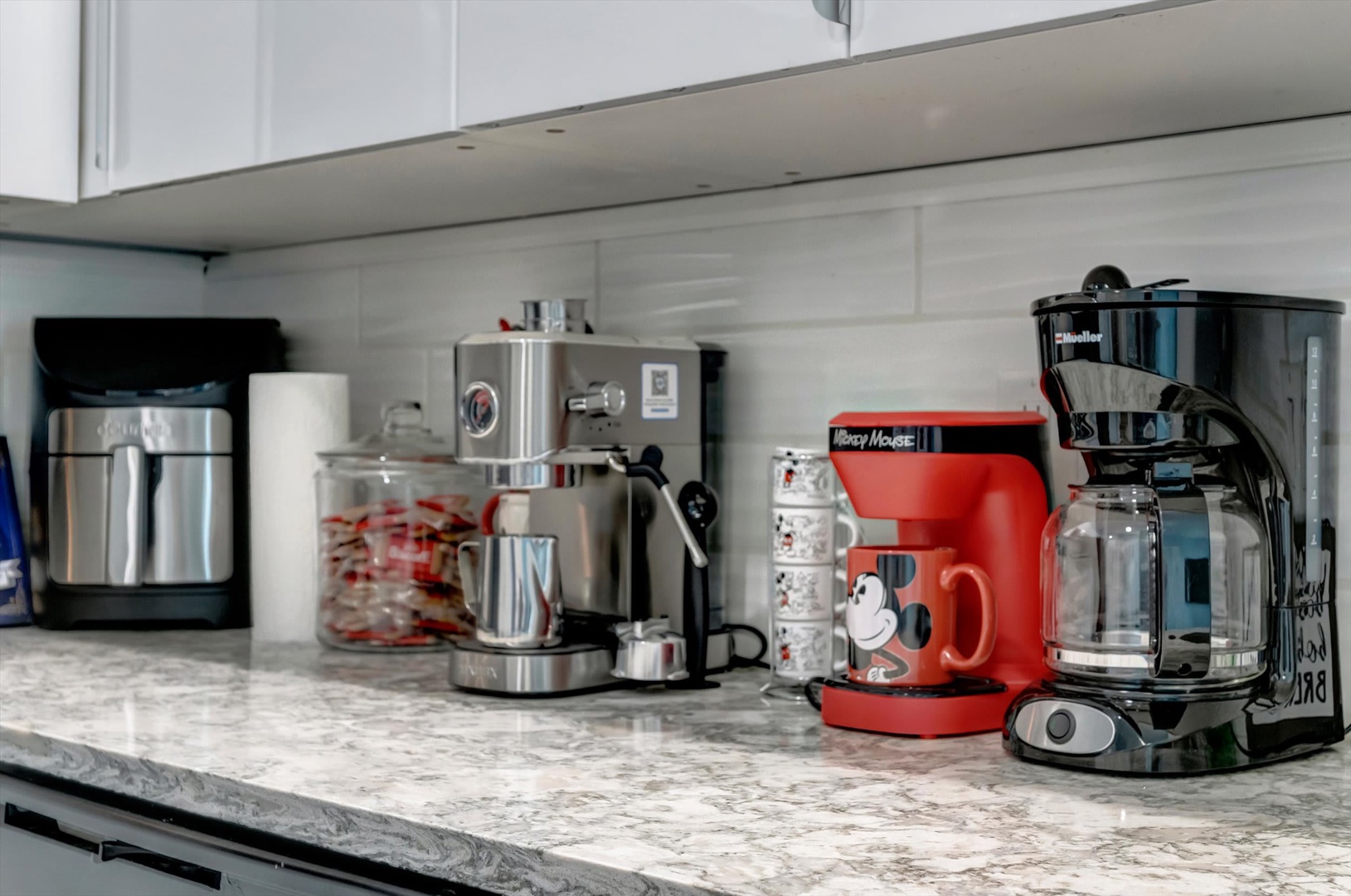 Your morning coffee awaits with a full array of brewing options, from espresso to drip, all set up on gleaming counters in your fully-equipped kitchen.
