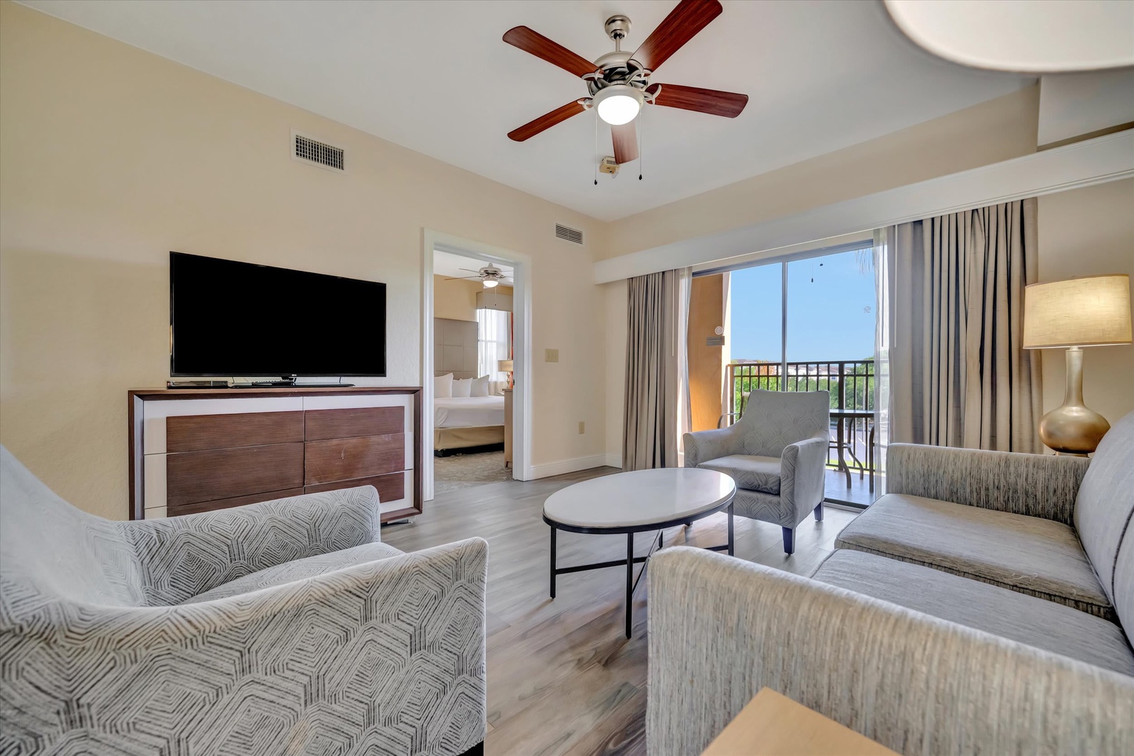 Unwind in your spacious suite with soft seating, a ceiling fan to keep you cool, and balcony doors that open to let in fresh air and glimpses of green.