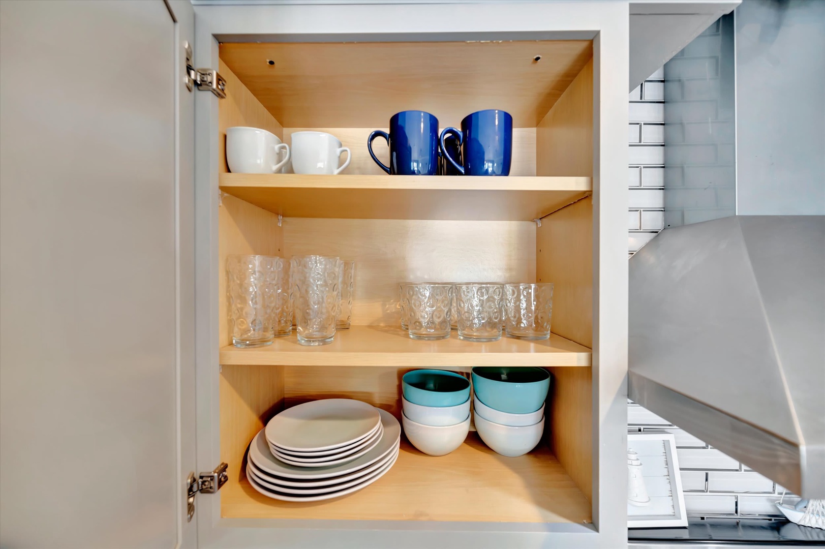 Your kitchen comes thoughtfully stocked with plates, bowls, glassware, and colorful mugs—everything you need to feel at home while preparing meals or enjoying morning coffee.