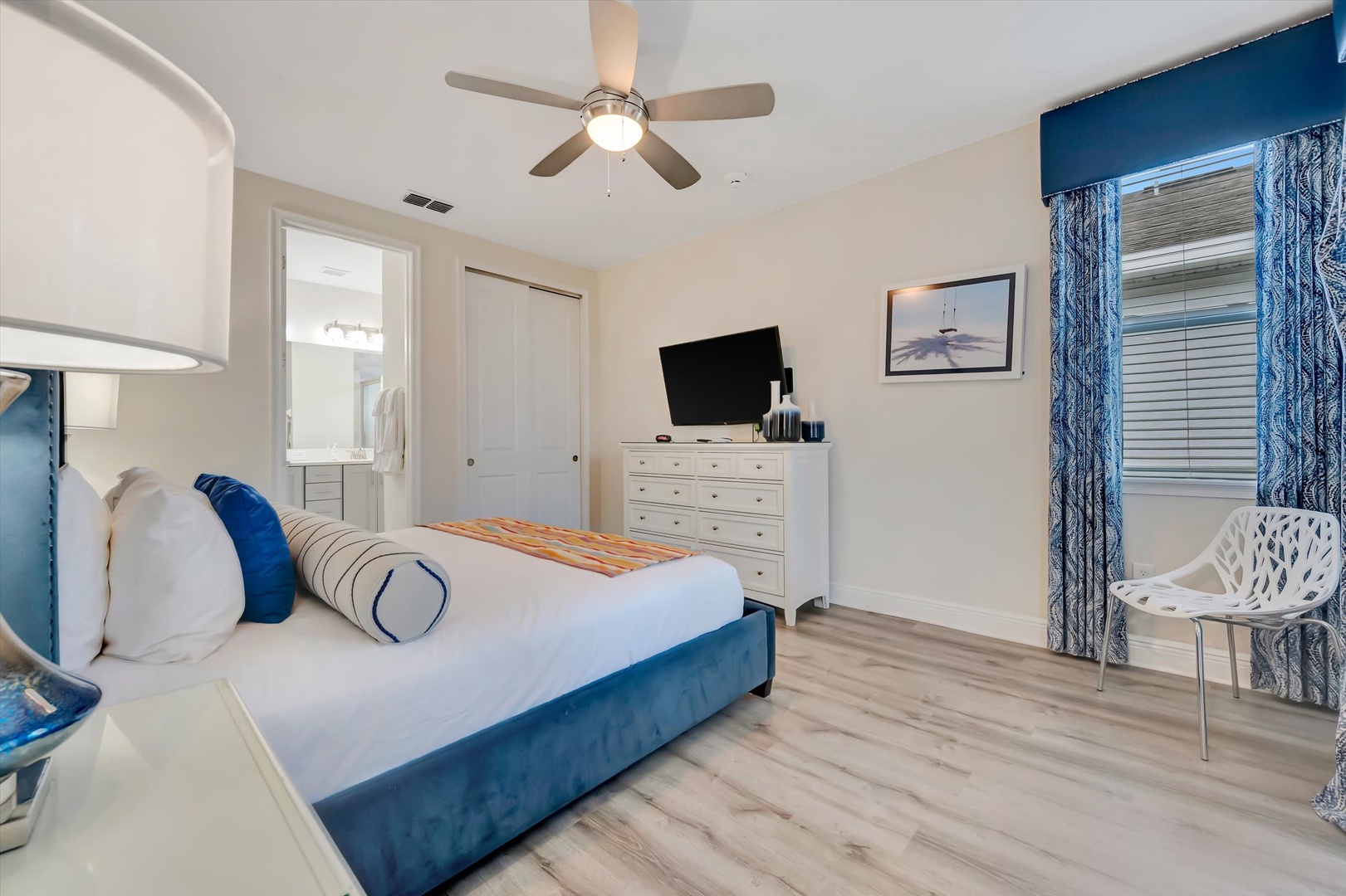 Sink into your plush bed with its coastal blue accents and enjoy the gentle breeze from your ceiling fan. Your private ensuite awaits through the doorway, making this retreat feel like home.