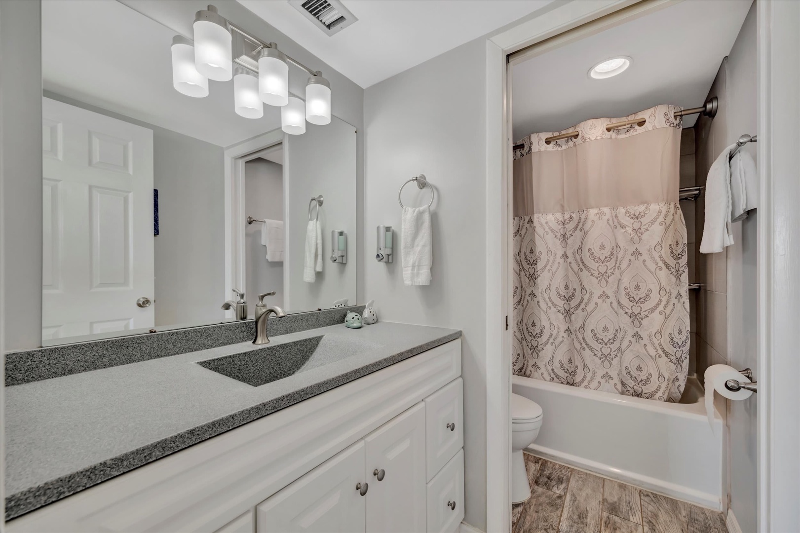 Freshen up in your bright, modern bathroom with ample counter space and a relaxing tub. Clean lines and soft lighting create a tranquil retreat for your morning routine.