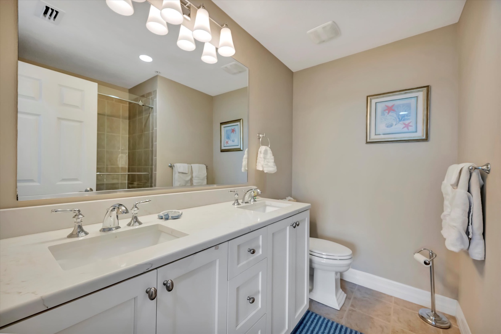 Freshen up in this elegantly appointed bathroom featuring dual vanities, a spacious walk-in shower, and soft lighting that creates a spa-like atmosphere perfect for your morning routine.