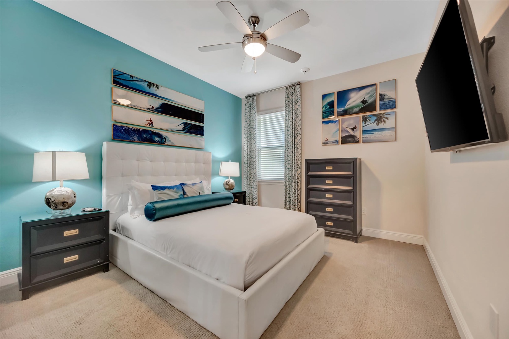 Drift off in your bright, coastal-inspired bedroom with a plush bed, calming turquoise accent wall, and modern décor that captures the spirit of a beachside retreat.