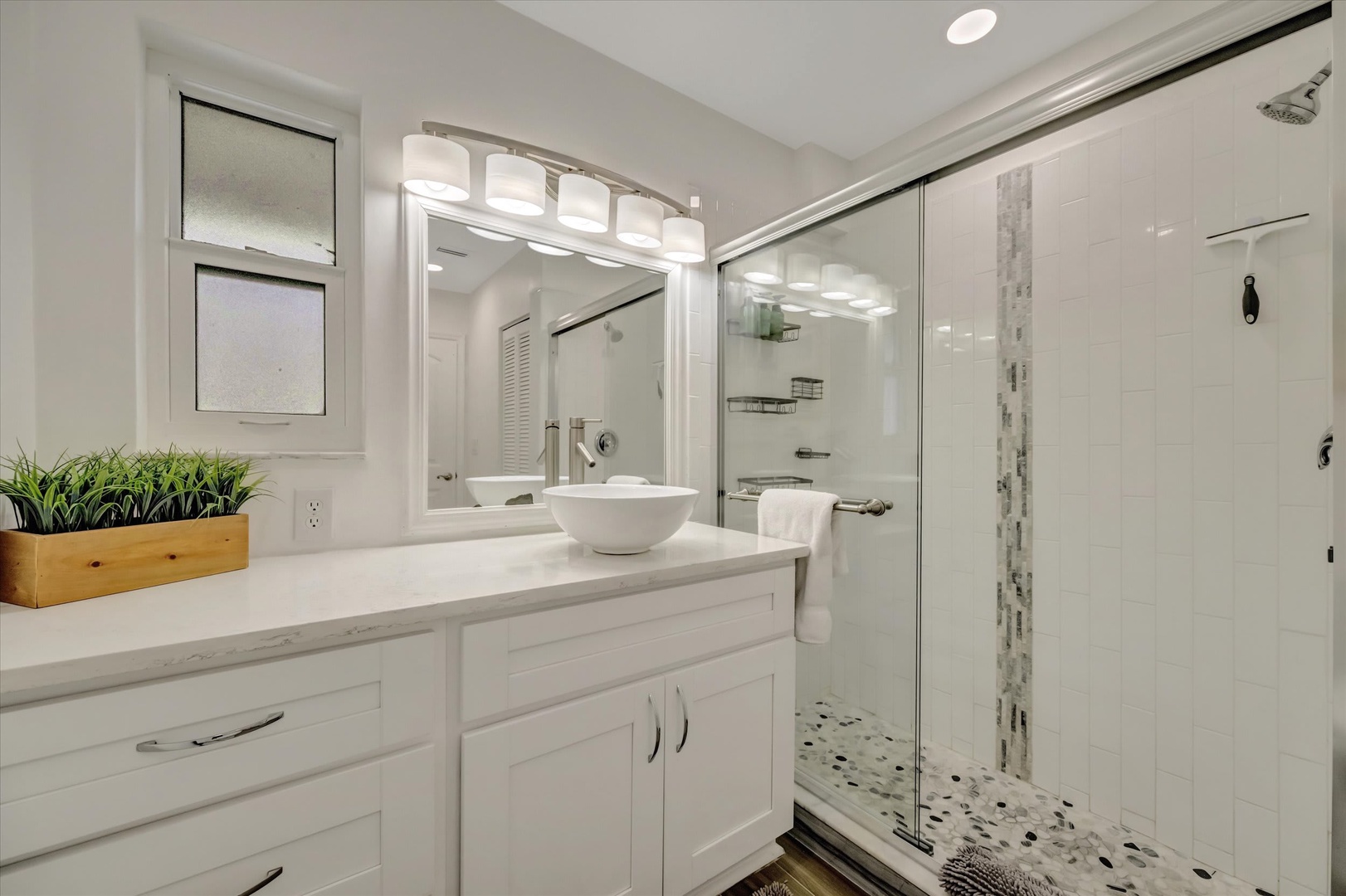 Step into your spa-like bathroom, where bright white tiles and a spacious walk-in shower invite you to refresh and unwind in style.