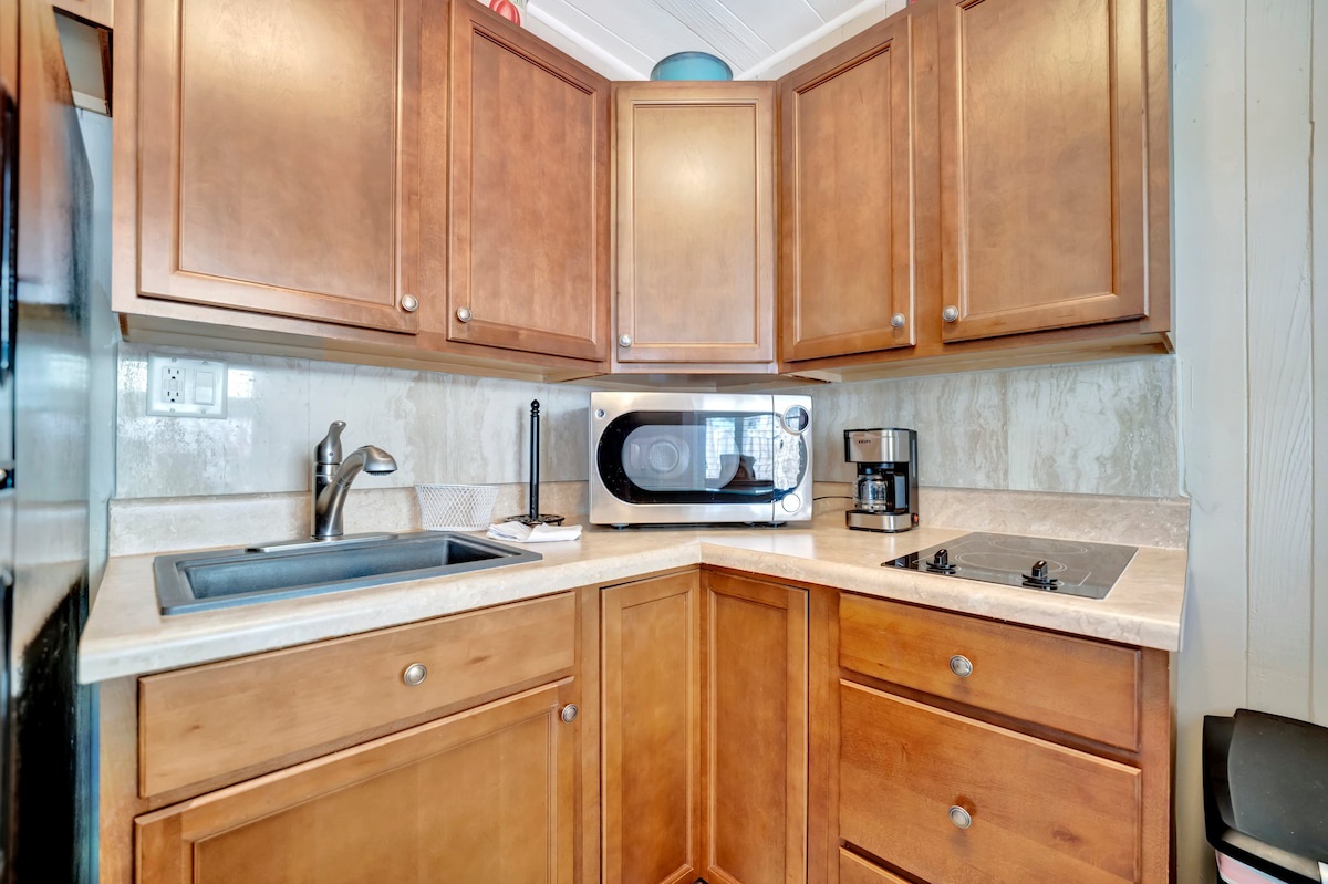 Your fully equipped kitchen offers everything you need to whip up a quick breakfast or prepare a home-cooked meal during your stay, with warm wood cabinetry and modern appliances at your fingertips.