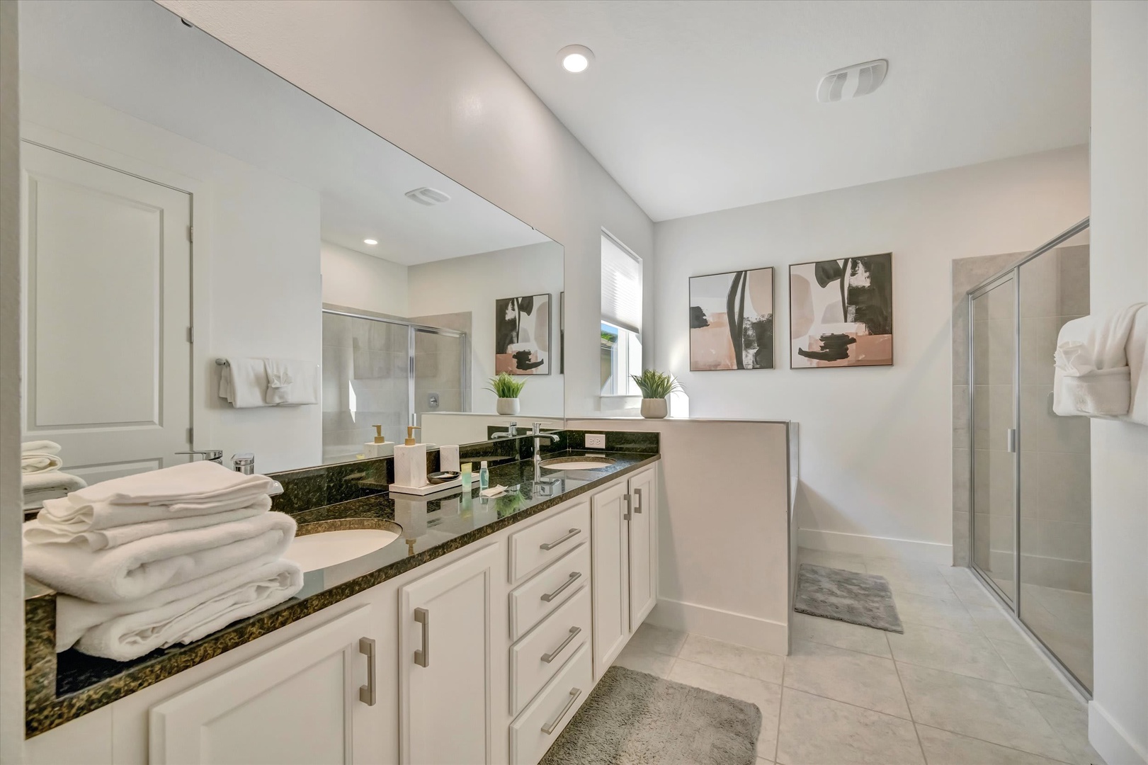 You'll love the sleek double vanity and spacious walk-in shower—crisp, modern design with everything you need to feel refreshed and ready for the day.
