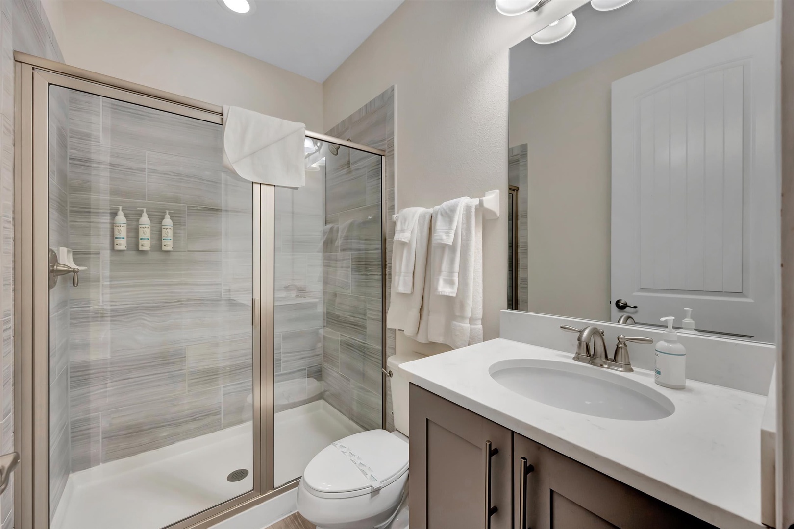 Your private bathroom features a spacious walk-in shower with elegant tile work, fluffy towels, and a modern vanity. Everything you need to refresh after a day of exploring.