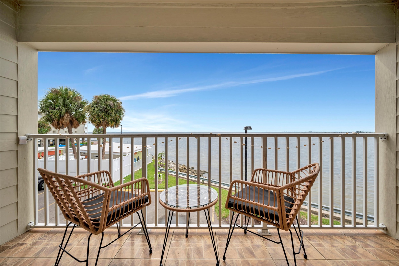 Sip your morning coffee from your private balcony overlooking the water and swaying palm trees—your perfect escape begins here.