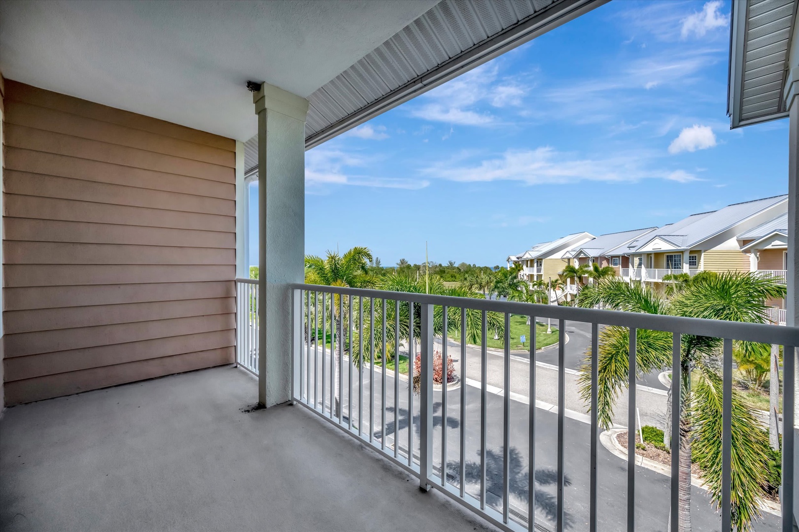 Step out onto your private balcony and breathe in the fresh tropical air. Palm trees sway in the breeze, framing views of the sunny neighborhood below—a perfect spot for morning coffee.
