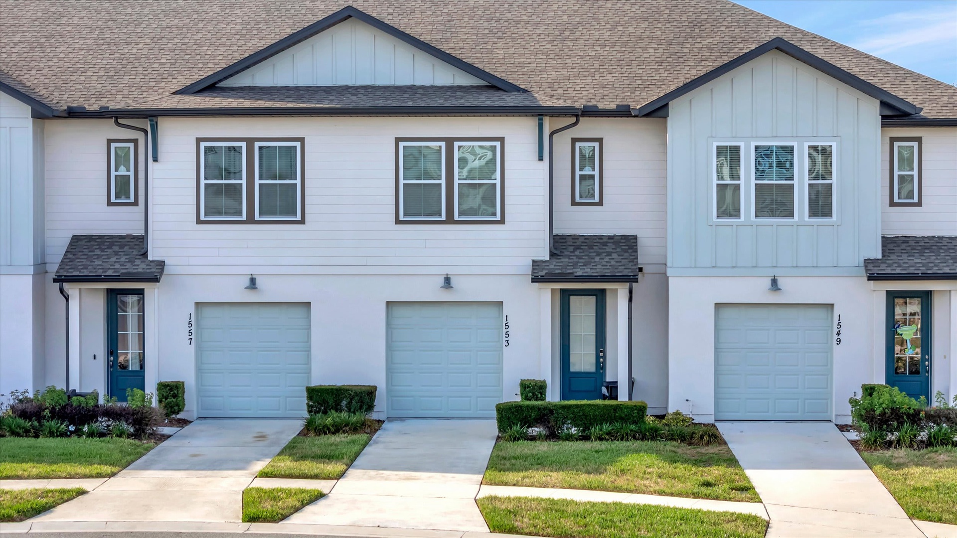 Modern townhome community featuring contemporary architecture with clean lines, private garages, and well-maintained landscaping in a peaceful neighborhood setting.