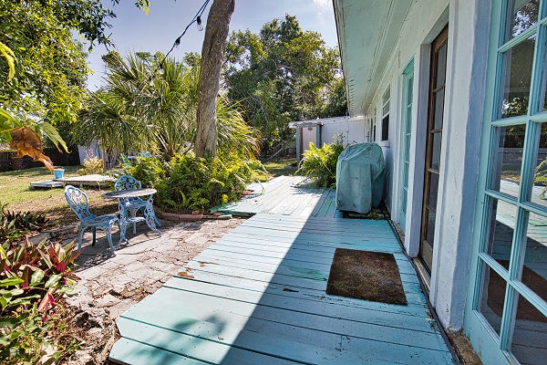 Step onto your private deck and breathe in the tropical garden air. A shaded patio with outdoor seating invites you to unwind surrounded by lush palms and mature trees.